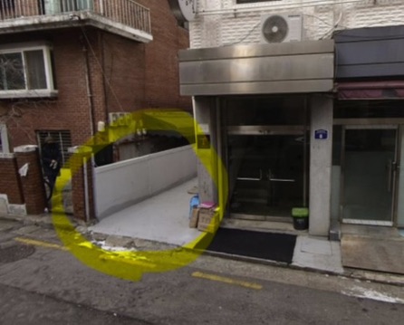 후킹스튜디오 건물 입구 옆 무료 주차 공간이 노란색으로 표시된 사진